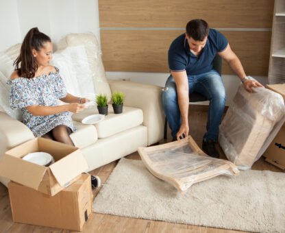 Young couple Moving in new home and unpacking carboard boxes