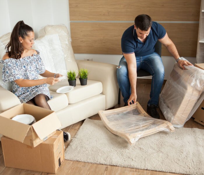 Young couple Moving in new home and unpacking carboard boxes